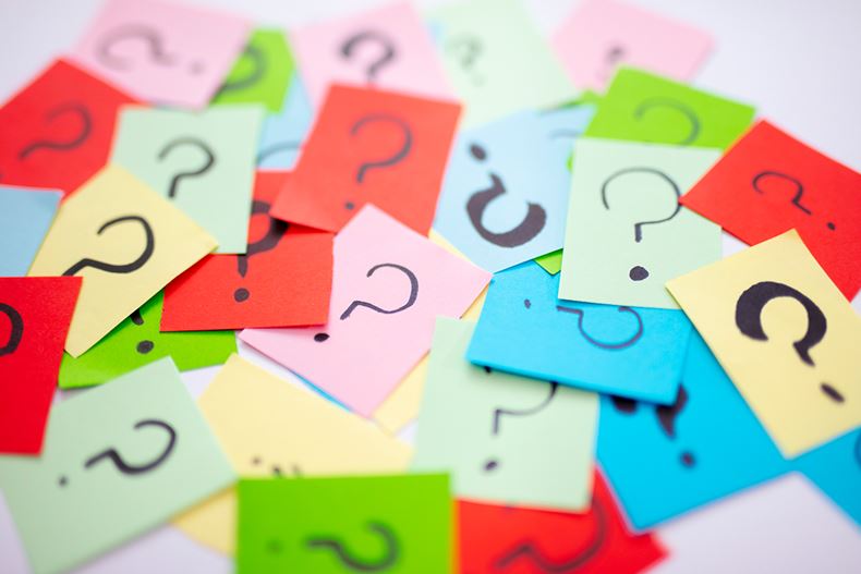Question marks drawn on scattered colourful post-it notes
